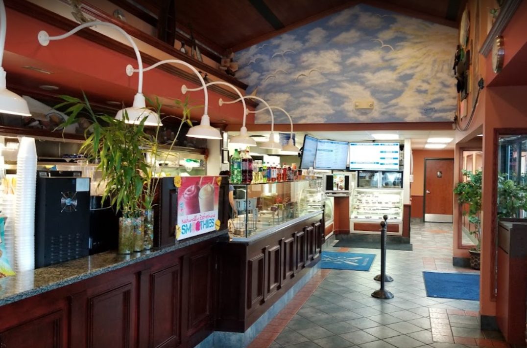 Inside Nautical Deli — the counter, menu boards and sky-painted ceiling